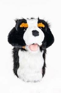 A synthetic sheepskin golf club headcover designed to resemble a dog's head, primarily in black, white, and orange colors.
