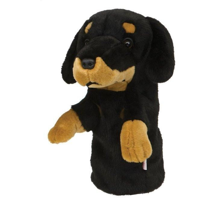 A synthetic golf club headcover designed to resemble a dog's head, primarily black with some brown coloring.