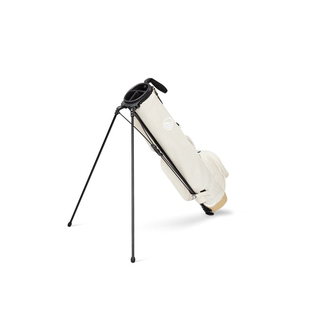 A beige golf bag with black straps and accents, featuring multiple pockets and a stand system, set against a white background.