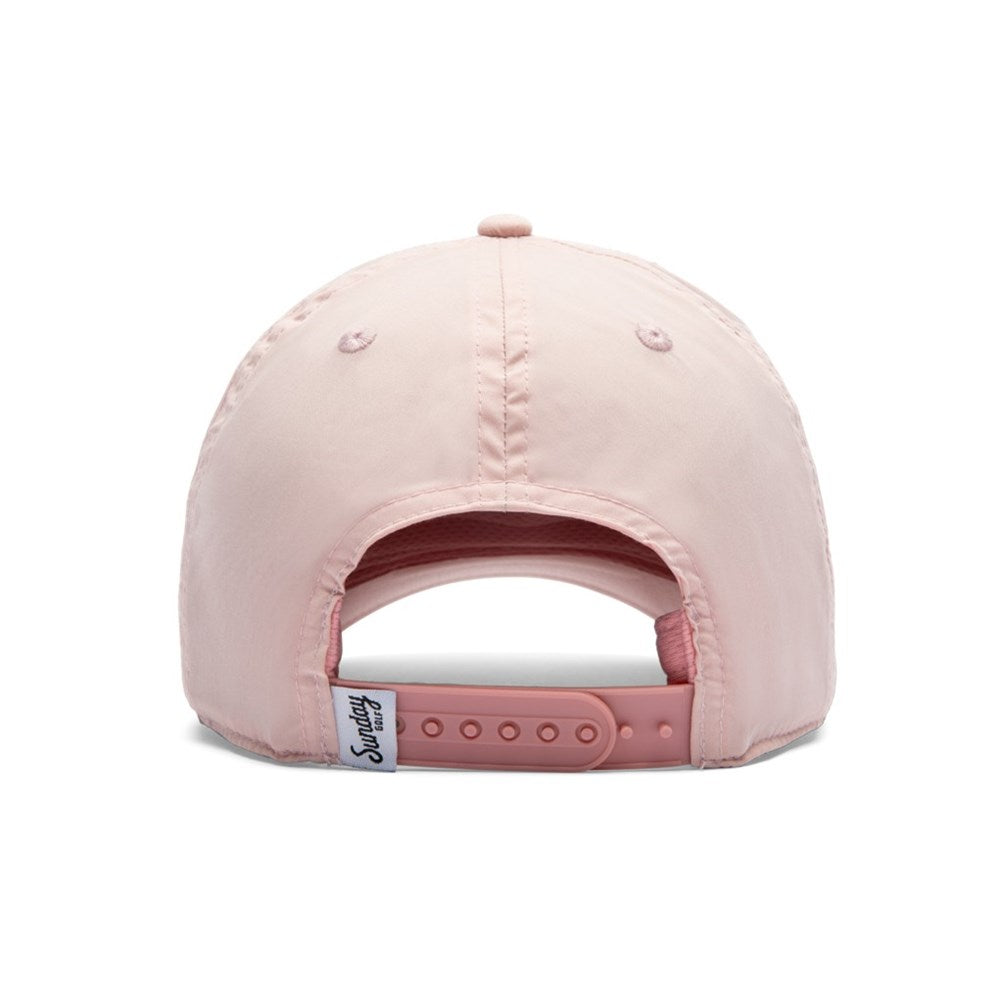 A pink golf hat with 'Sunday Golf' text on the front and a white athletic sweatband.