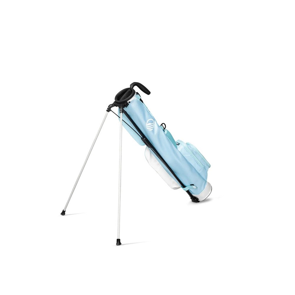 A light blue golf bag with a stand mechanism deployed, featuring multiple pockets and a shoulder strap while support stand being used.
