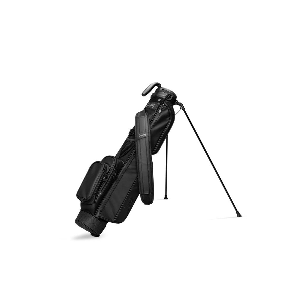 A black golf bag with a stand system, featuring multiple pockets and a shoulder strap.
