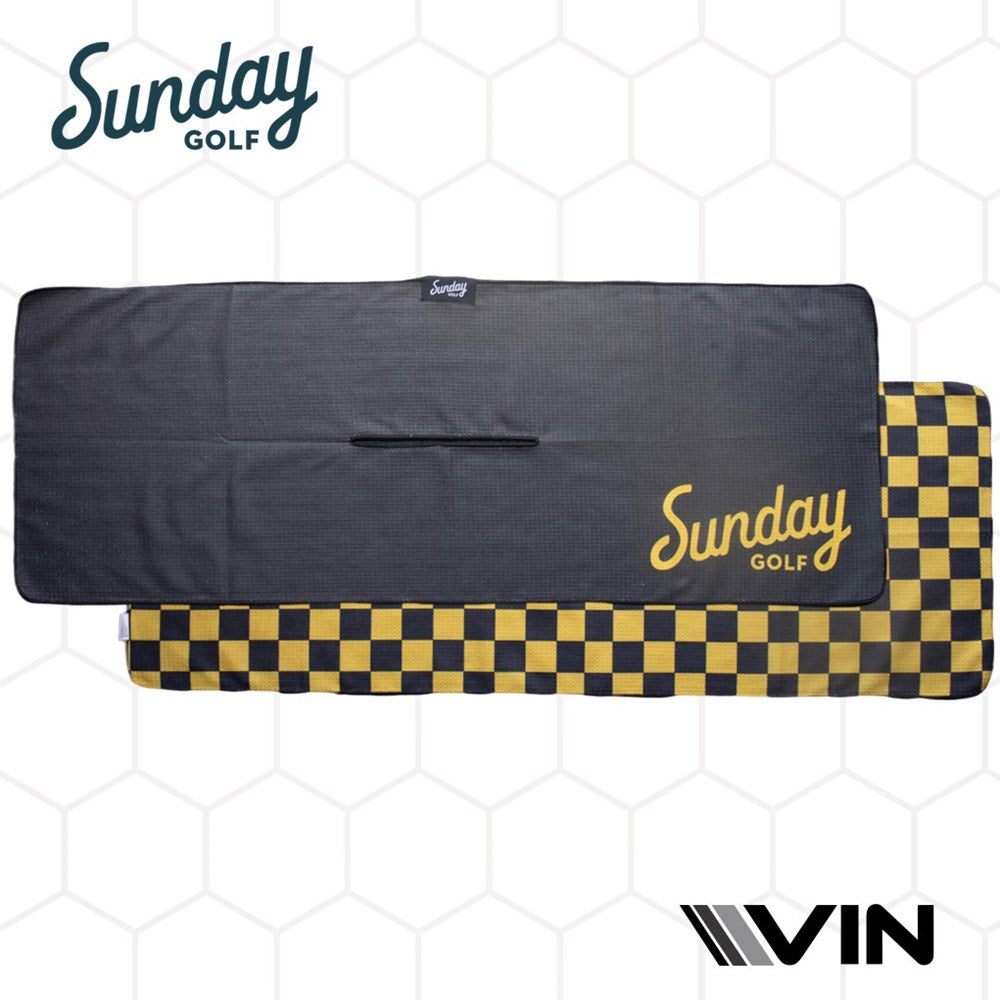 A black golf towel with a yellow checkered pattern on the lower right corner, featuring the 'Sunday Golf' logo in yellow and white, displayed on a hexagonal background.