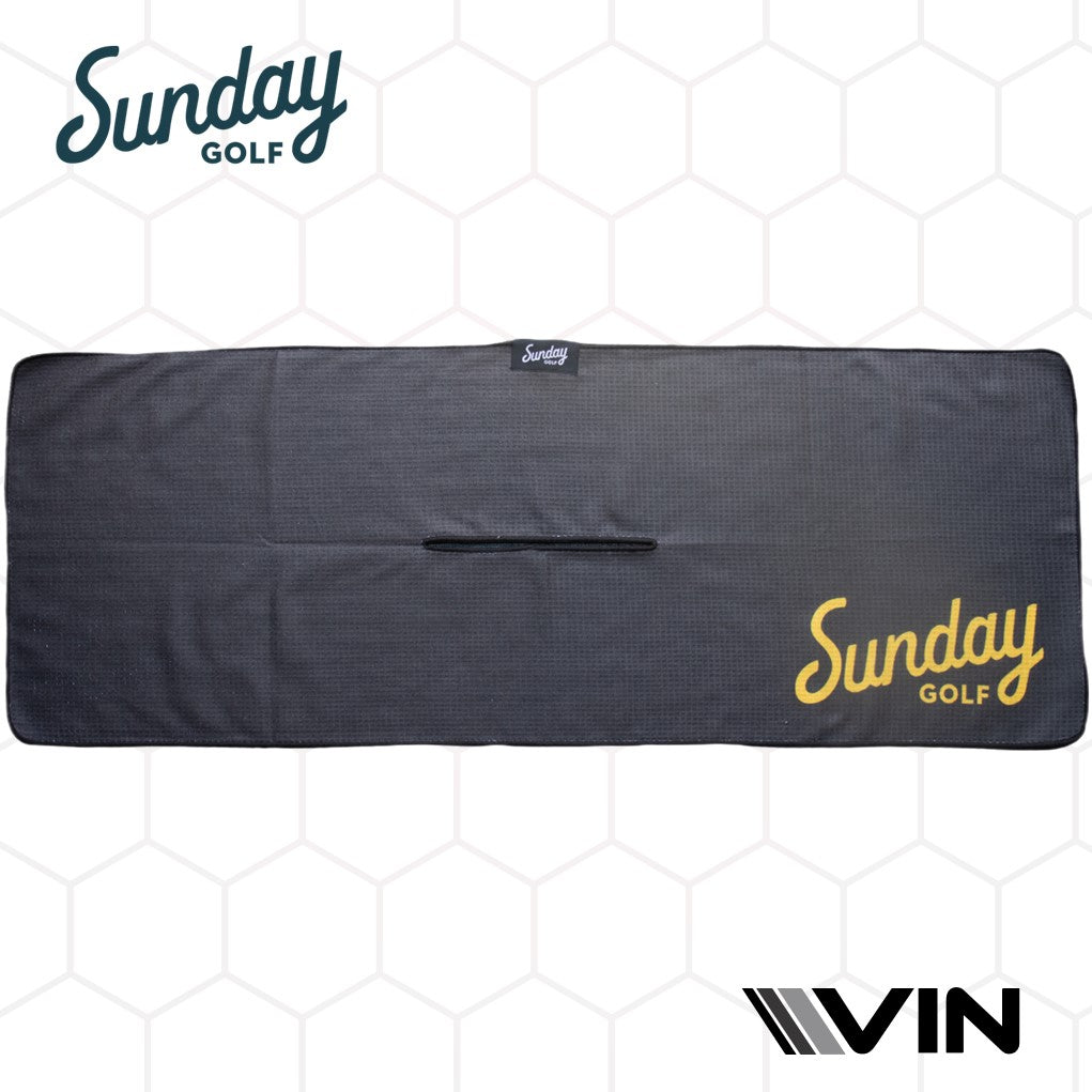 A black golf towel with a yellow checkered pattern on the lower right corner, featuring the 'Sunday Golf' logo in yellow and white, displayed on a hexagonal background.