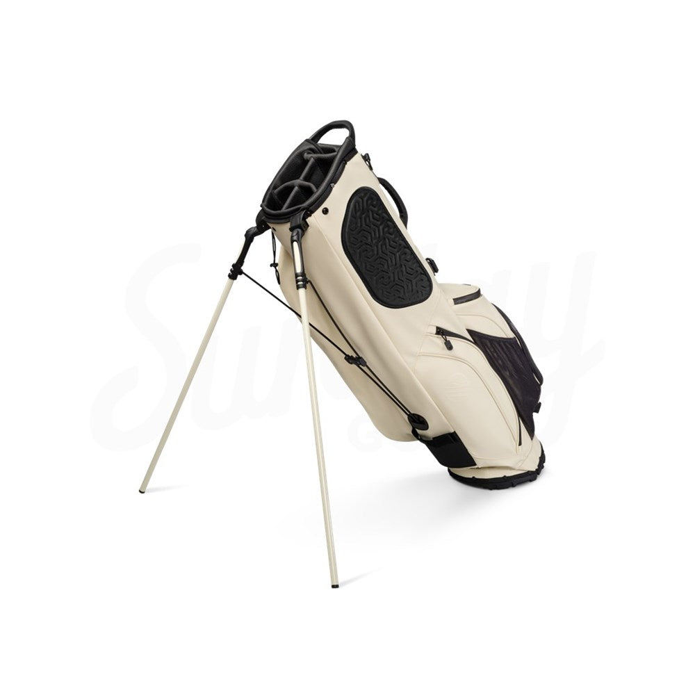 Beige and black golf bag with stand on a white background